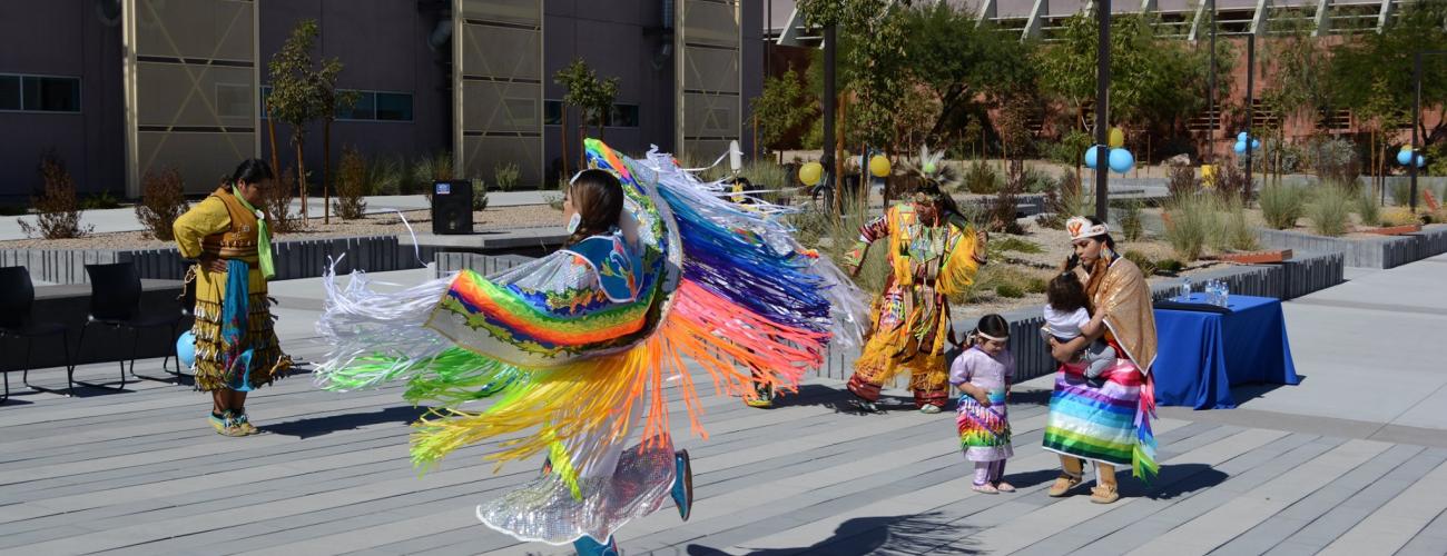 Native American performers dancing in traditional garments